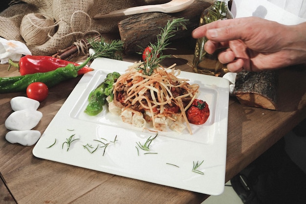 Kucharz przygotowujący talerz z makaronem